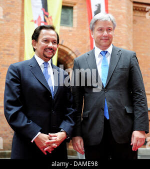 Sindaco di Berlino Klaus Wowereit (C) e il Sultano del Brunei, Haji Hassanal Bolkiah (L), stand nel cortile del rosso Municipio di Berlino, Germania, 08 giugno 2011. In background, sulla destra è la bandiera di Berlino e sulla sinistra è la bandiera del Brunei. Il Sultan è una politica della visita a Berlino. Foto: Annibale Foto Stock