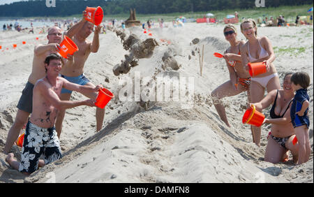 I partecipanti del sandcastle tentativo di record Joern (L-R), Thomas, Silvio, Andrea, Elisa, Christine e Tonio costruire un castello di sabbia sulla spiaggia della località balneare Glowe sull isola di Ruegen, Germania, 12 giugno 2011. È prevista la costruzione di castelli di sabbia più lunga del mondo. Con una lunghezza di 27,5 km di questo sandcastle deve superare il vecchio record di castelli di sabbia di 26.38 Km Foto Stock