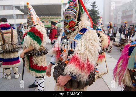 Mummers Kukerlandia vestito in vivaci costumi colorati intrattengono il pubblico durante il festival Kukerlandia Bulgaria Foto Stock