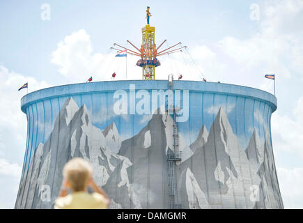 Un visitatore del 'Wunderland Kalkar' Amusement Park sorge nella parte anteriore di un ex torre di raffreddamento a Kalkar, Germania, il 9 giugno 2011. Nel 1995, l'olandese van der la maggior parte ha acquistato la ex centrale nucleare 'Schneller Brueter' e trasformato in un hotel e il centro per il tempo libero. Foto: Victoria Bonn-Meuser Foto Stock