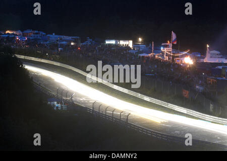 Vetture da gara lasciare tracce dei fari durante la 24 Ore del Nuerburgring gara di Nuerburg, Germania, 25 giugno 2011. 250 auto partecipare alla gara sull'anello north loop, gli organizzatori si aspettano 200.000 spettatori. Foto: Thomas Frey Foto Stock