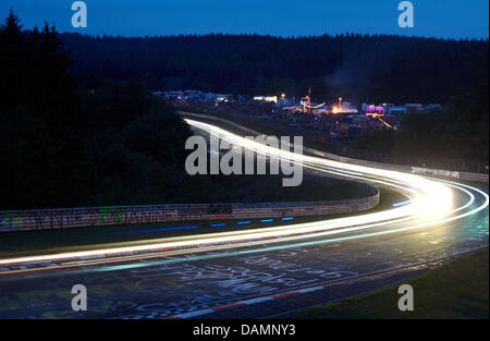 Vetture da gara lasciare tracce dei fari durante la 24 Ore del Nuerburgring gara di Nuerburg, Germania, 25 giugno 2011. 250 auto partecipare alla gara sull'anello north loop, gli organizzatori si aspettano 200.000 spettatori. Foto: Thomas Frey Foto Stock