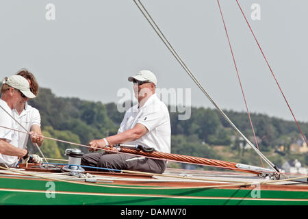 Il re Harald V di Norvegia (R) si siede al timone della sua barca Sira come skipper al Quellental marina a Glücksburg, Germania, 29 giugno 2011. Il monarca norvegese sta prendendo parte al 'Rolex Baltic Week" regata a vela e quest'anno il 8-classe di Misuratore campionati del mondo in 73 anni di proprietà di una famiglia yacht. Foto: Markus Scholz Foto Stock