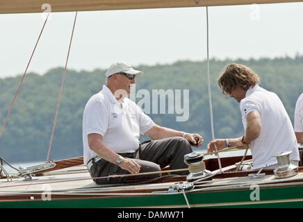 Il re Harald V di Norvegia (L) si siede al timone della sua barca Sira come skipper al Quellental marina a Glücksburg, Germania, 29 giugno 2011. Il monarca norvegese sta prendendo parte al 'Rolex Baltic Week" regata a vela e quest'anno il 8-classe di Misuratore campionati del mondo in 73 anni di proprietà di una famiglia yacht. Foto: Markus Scholz Foto Stock