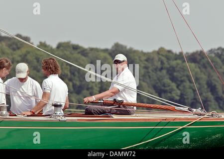 Il re Harald V di Norvegia (R) si siede al timone della sua barca Sira come skipper al Quellental marina a Glücksburg, Germania, 29 giugno 2011. Il monarca norvegese sta prendendo parte al 'Rolex Baltic Week" regata a vela e quest'anno il 8-classe di Misuratore campionati del mondo in 73 anni di proprietà di una famiglia yacht. Foto: Markus Scholz Foto Stock