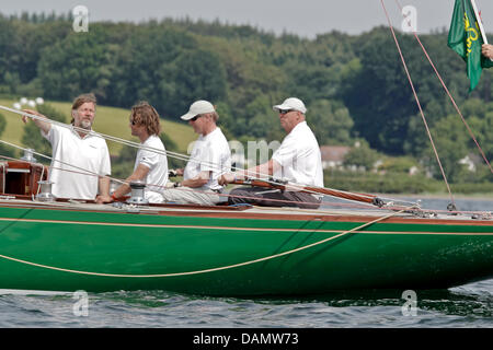 Il re Harald V di Norvegia (R) si siede al timone della sua barca Sira come skipper al Quellental marina a Glücksburg, Germania, 29 giugno 2011. Il monarca norvegese sta prendendo parte al 'Rolex Baltic Week" regata a vela e quest'anno il 8-classe di Misuratore campionati del mondo in 73 anni di proprietà di una famiglia yacht. Foto: Markus Scholz Foto Stock