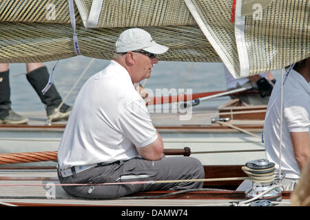 Il re Harald V di Norvegia (L) si siede al timone della sua barca Sira come skipper al Quellental marina a Glücksburg, Germania, 29 giugno 2011. Il monarca norvegese sta prendendo parte al 'Rolex Baltic Week" regata a vela e quest'anno il 8-classe di Misuratore campionati del mondo in 73 anni di proprietà di una famiglia yacht. Foto: Markus Scholz Foto Stock