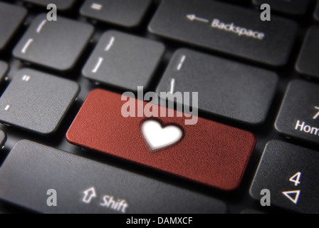 Amore online concetto chiave con icona a forma di cuore sulla tastiera del notebook. Incluso percorso di clipping, così puoi modificare facilmente. Foto Stock