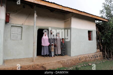 Agricoltore Aminad cucite (L-R), suo marito Hussein Gezaw e i loro figli a stare di fronte alla loro casa in Illukawa, Etiopia, il 25 giugno 2011. Dopo anni di sostegno "persone per le persone' ('Menschen fuer Menschen") Fondazione tirato fuori il progetto Dera regione perché la situazione è migliorata in modo significativo. Foto: Tobias Hase Foto Stock