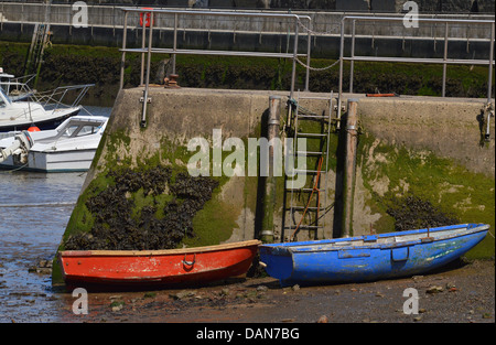 2 piccole imbarcazioni - uno rosso , uno blu - ormeggiata al Porto di Staithes beach , North Yorkshire Foto Stock