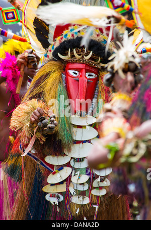 Uomo vestito in un colorato spirito ornamentali costume con una maschera rossa a Goroka Show in Papua Nuova Guinea Foto Stock