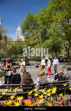 Per coloro che godono di una giornata di sole in Madison Square Park con l'Empire State Building in background, NYC Foto Stock
