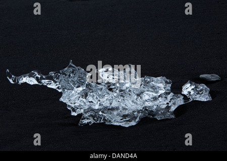 Iceberg depositato sul nero di cenere vulcanica Jökulsárlón 'fiume glaciale" laguna sud dell'Islanda europa oceano Atlantico Giugno Foto Stock