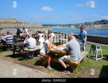 I visitatori di St.Michaels Mount in Cornovaglia godendo la crema tè al cafe sull'isola Foto Stock