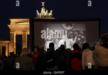 Le persone che frequentano lo screening di Charlie Chaplin "Il grande dittatore" presso la Porta di Brandeburgo a Berlino, Germania, 15 giugno 2011. Il silent film festival "Chaplin completa' aperto con la proiezione a segno distintivo della citta'. Foto: Wolfgang Kumm Foto Stock