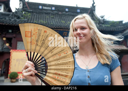 L'immagine resa disponibile il 20 luglio 2011 mostra nuotatore tedesco Britta Steffen lusinghiero una ventola durante una visita di Cheng Huang Miao Temple nel Giardino di Yu prima del 2011 FINA Campionati Mondiali di Nuoto a Shanghai in Cina, 18 luglio 2011. Foto: Bernd Thissen dpa Foto Stock