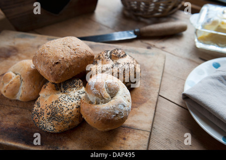Pane appena sfornato rotola su un tavolo da cucina Foto Stock