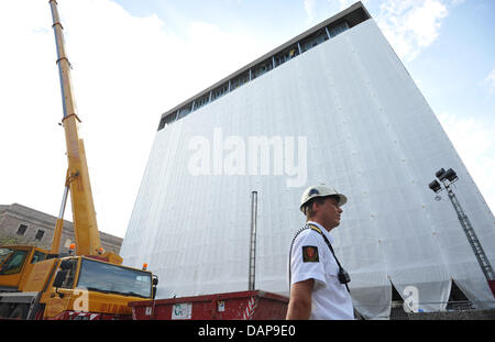 Una guardia di sicurezza si trova di fronte al danneggiato la sede ufficiale del Primo Ministro norvegese che è coperta bianca con fogli di plastica a Oslo, Norvegia, 03 agosto 2011. 77 persone sono morte durante gli attacchi il 22 luglio 2011 e otto delle vittime sono morte a causa di un auto bomba che andò via nel quartiere governativo di Oslo. Foto: Rainer Jensen Foto Stock