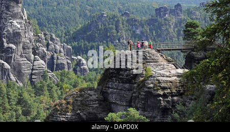 Gli escursionisti a stare di fronte di rocce di arenaria della Svizzera sassone in Rathen, Germania, 12 agosto 2011. Un cosiddetto pittore sentiero conduce attraverso le rocce dal 2006, che è stato chiamato dopo il pittore del periodo romantico che hanno trovato i loro motivi in questa regione. Il 14 agosto 2011 il primo pittore percorso giornata sarà celebrata in occasione del quinto anniversario del percorso. Foto: MA Foto Stock