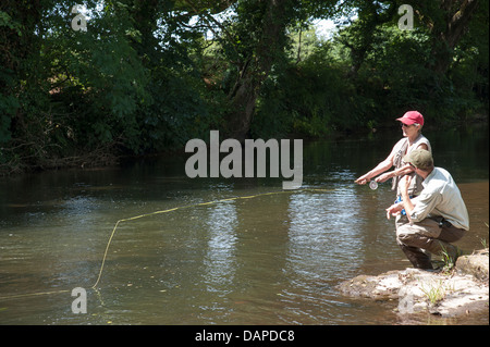La pesca a mosca un gillie istruire un allievo sul panoramico Fiume Lyd Devon England Regno Unito Foto Stock