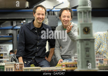 Fratelli Frederik (R) e Gerrit Braun, fondatori e amministratori delegati di Miniatur Wunderland (Wonderland in Miniatura), sedersi in Hamburg scenario del modello ferroviario ad Amburgo, Germania, 12 agosto 2011. Miniatur Wunderland celebra il suo decimo anniversario il martedì. Sin dalla sua apertura il 16 agosto 2001, circa 8,3 milioni di visitatori sono venuti a vedere la più grande del mondo di modello r Foto Stock