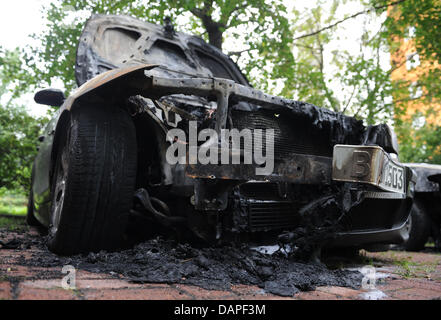 Un bruciata BMW sorge su un parcheggio a Berlino, Germania, 17 agosto 2011. Da anni ormai ogni notte gli attacchi incendiari su vetture hanno luogo a Berlino. Durante la notte del 16 agosto 2011, 17 vetture bruciate. Foto: Rainer Jensen Foto Stock