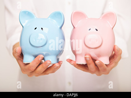 Donna che mantiene due banche moneta Foto Stock