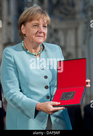 Il cancelliere tedesco Angela Merkel detiene la medaglia di Kaiser Otto Award all interno della Cattedrale di Magdeburgo, Germania, 24 agosto 2011. Il premio porta il nome di Ottone I il Grande (912-973) che è noto come il fondatore del Sacro Romano Impero e precursore dell'Europa. Egli è furono sepolti nella Cattedrale di Magdeburgo. Foto: Jens Wolf Foto Stock