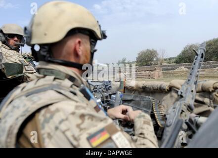 Esercito Tedesco soldati guidare passato un serbatoio bombardato, che era stato distrutto al comando del colonnello tedesco, nel Chahar Dara quartiere vicino a Kunduz, Afghanistan, 01 settembre 2011. Forze armate tedesche sono continuamente coinvolti in scontri militari nel Nord dell'Afghanistan. Foto: MAURIZIO GAMBARINI Foto Stock