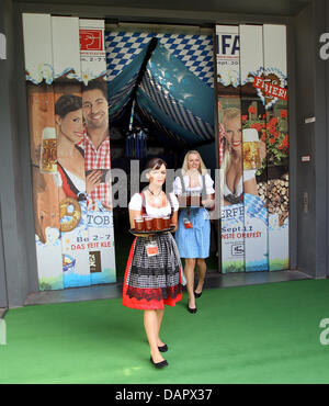 Due hostess offrono la birra all'interno del più piccolo al mondo 'Oktoberfest' birra tenda all'apertura dell'IFA 2011 fiera di elettronica di consumo ed elettrodomestici a Berlino, Germania, 02 settembre 2011. I visitatori possono sedersi sulle panchine all'interno di un materiale sollevare (indietro) nella hall 5, gustare una birra e di essere elevata ad altri luoghi espositivi. L' IFA apre le sue porte a partire dal 2 settembre 2011 al 7 S Foto Stock