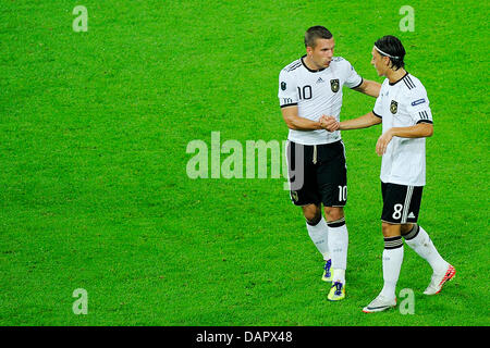 La Germania Mesut Oezil (r) festeggia con il compagno di squadra Lukas Podolski dopo il punteggio 2-0 durante il loro EURO 2012 Gruppo qualificatore di un match vs Germania Austria a Arena Auf Schalke di Gelsenkirchen, Germania, 02 settembre 2011. Foto: Marius Becker dpa/lnw +++(c) dpa - Bildfunk+++ Foto Stock