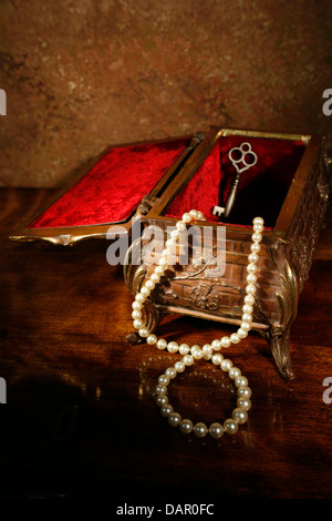 Una chiave e la collana di perle in un bellissimo legno ornamentali box Foto Stock