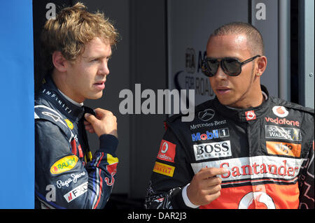 Tedesco di Formula Uno pilota Sebastian Vettel della Red Bull (L - 1°) e il britannico Lewis Hamilton della McLaren (2a) a piedi attraverso il parc ferme dopo la sessione di qualifica in pista Autodromo Nazionale di Monza, Italia, 10 settembre 2011. Il Gran Premio di Formula Uno di Italia si svolgerà il 11 settembre 2011. Foto: David Ebener dpa Foto Stock