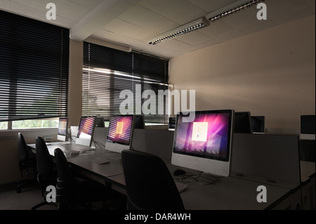 La fine della scuola o college come sappiamo che le righe di computer nel buio di una classe molto precedentemente utilizzato per ora in attesa di essere utilizzati Foto Stock