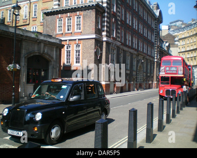 Questa immagine cattura le strade trafficate di Londra, in Inghilterra, con il tipico traffico urbano. La scena include gli iconici autobus rossi a due piani e i taxi neri, che sono luoghi comuni a Londra. Il paesaggio architettonico della città è un mix di edifici moderni e storici, che riflettono la sua lunga storia e le infrastrutture moderne. Foto Stock