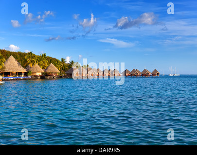 Tipico paesaggio Polinesiano - piccole case sull'acqua. Foto Stock