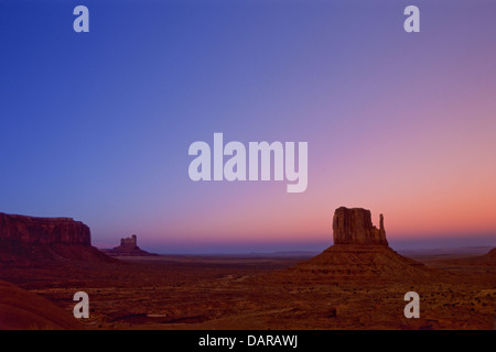 Monument Valley Navajo Tribal Park con il bagliore del tramonto che dipinge il cielo dietro il West Mitten in Arizona/Utah. (USA) Foto Stock