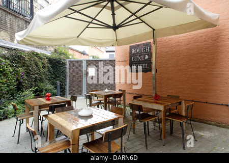 Rough Luxe, Londra, Regno Unito. Architetto: Rabih Hage, 2008. Al di fuori di una zona pranzo. Foto Stock