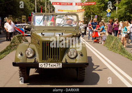 Uomo al vecchio retrò jeep militari uaz su strada Foto Stock