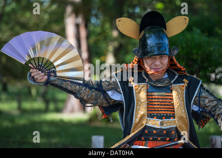 Un attore in Samurai Armor tenendo Un giapponese ventola di guerra, i Giardini del Castello di Nagoya, Nagoya, Giappone Foto Stock
