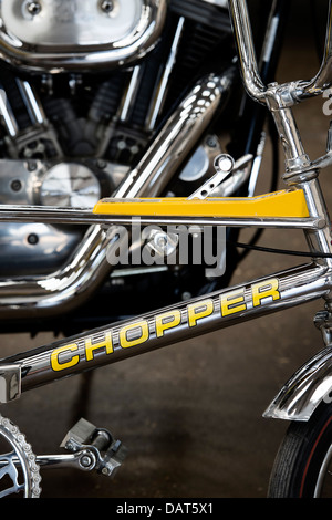 Chrome Raleigh bicicletta chopper davanti a un Harley Davidson Moto Foto Stock