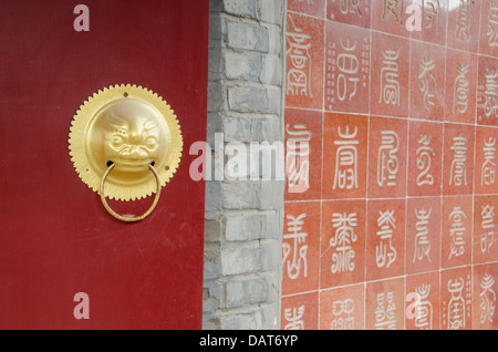 Cina, Provincia di Ji, Tianjin. La Grande Muraglia della Cina, Huangyaguan. Parete del tempio dettaglio con caratteri e porta in ottone accento. Foto Stock