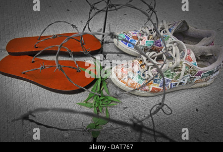 Due paia di scarpe faccia a faccia: prigioniera flip-flop e scarpe di libertà (coperto con timbri). Il filo spinato che li separa Foto Stock