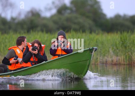 Gruppo di fotografi di fauna selvatica facendo un giro in barca. L'Europa, Estonia, Alam-Pedja Riserva Naturale. Foto Stock