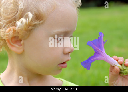 Ragazza bionda con fiore violaceo Foto Stock