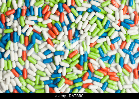 Grande quantità di pillole con diversi colori che stabilisce in una pila Foto Stock