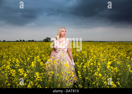 Donna in piedi nel campo in aperta campagna con la coltura di semi oleosi Foto Stock