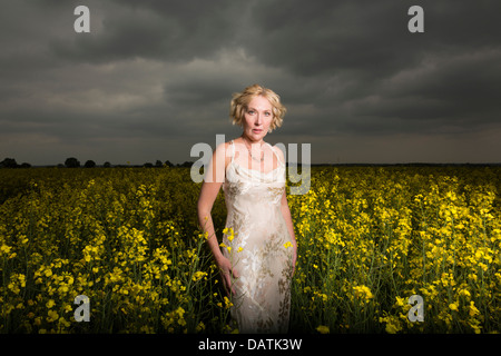 Donna in piedi nel campo in aperta campagna Foto Stock