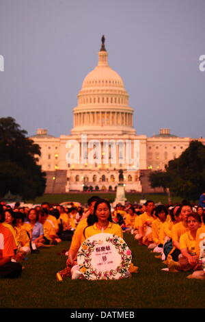 Washington DC, Stati Uniti d'America. 18 Luglio, 2013. Il Falun Gong membri commemorare il XIV anniversario del governo cinese la repressione contro di loro che è iniziato il XX luglio 1999. Alcune persone stanno tenendo i tributi con i nomi di coloro che sono stati uccisi durante la persecuzione. In fondo è la United States Capitol Building. Credito: James Brunker / Alamy Live News Foto Stock