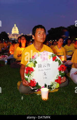 Washington DC, Stati Uniti d'America. 18 Luglio, 2013. Il Falun Gong membri commemorare il XIV anniversario del governo cinese la repressione contro di loro che è iniziato il XX luglio 1999. Alcune persone stanno tenendo i tributi con i nomi di coloro che sono stati uccisi durante la persecuzione. In fondo è la United States Capitol Building. Credito: James Brunker / Alamy Live News Foto Stock